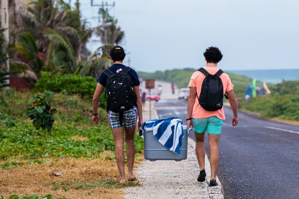 Two people carrying a Field Bar style ice cooler box outdoors